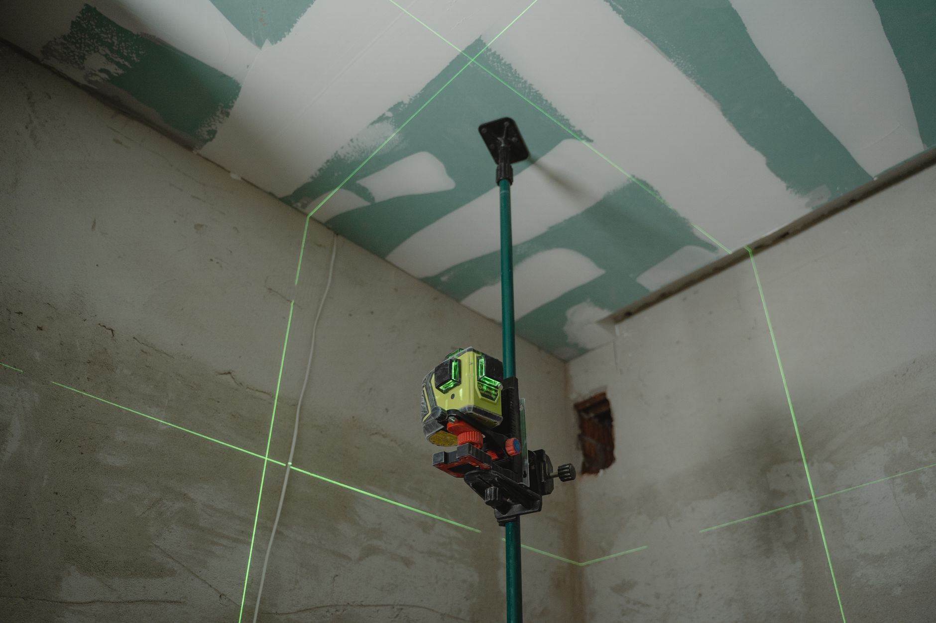 Lignes vertes d’un niveau laser projetées dans une pièce en rénovation